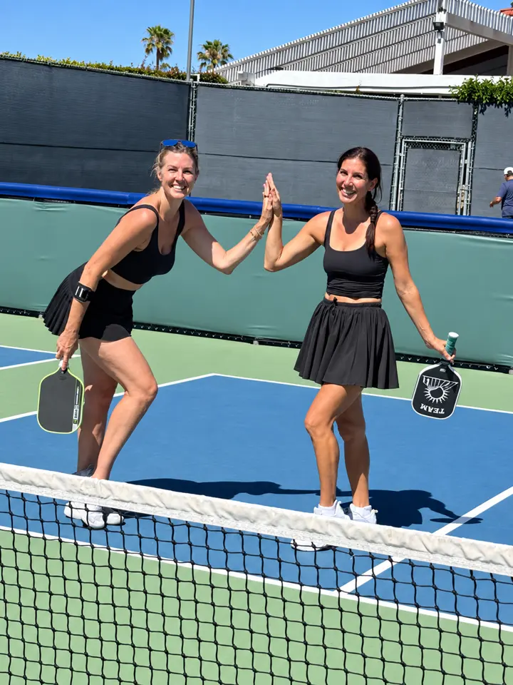 Jen and a player high-fiving at the net